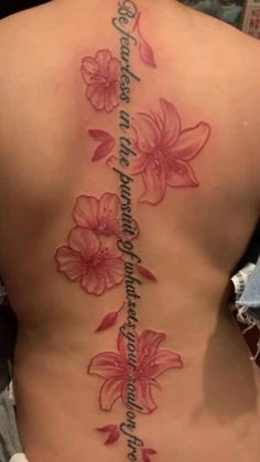 a woman's back with pink flowers on it and the words written in cursive writing