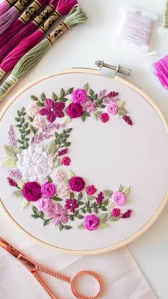 the embroidery is being worked on with scissors and thread, along with other crafting supplies