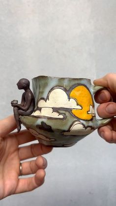 two hands holding a ceramic bowl with an image of a man and woman on it