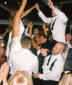 a group of people standing around each other in front of a man on the dance floor