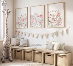 a giraffe is standing in front of three pictures on the wall above a bench