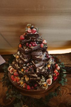 a chocolate cake with fruit and nuts on top sitting on a table next to a sign