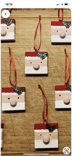 some wooden ornaments are hanging on the wall with red and white ribbon around them,