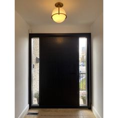 an empty hallway with a black door and light fixture