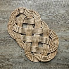 a knoted rope on top of a wooden table with knots in the center and bottom