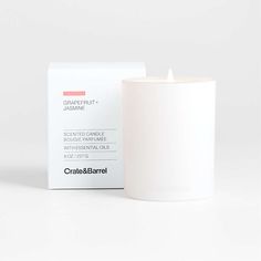 a white candle sitting next to a box on a table with the label in front of it