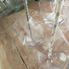 three clear cups with straws in them on a wooden table