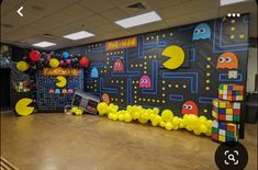 an office decorated with pac - man balloons and video game themed backdrops for a birthday party