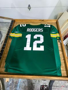 green bay packers jersey displayed in wooden box on display at shop window with other items