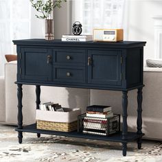 a black console table with books and magazines on it next to a couch in a living room