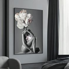 a black and white photo of a woman with flowers on her head sitting in front of a window