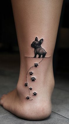 a small dog tattoo on the ankle with paw prints and an animal's head