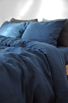 a bed with blue sheets and pillows on it