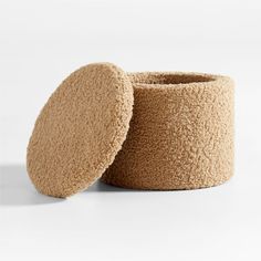 two round objects sitting next to each other on a white surface and one is made out of wool