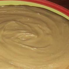 a bowl filled with peanut butter on top of a wooden table