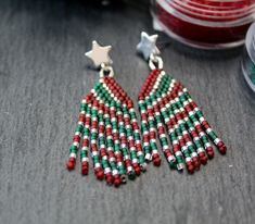 "Christmas Stripes" Oh My Holiday Joy, these are some true cuties. Red, green and silver stripes with silver plated stainless steel star studs. The green and red beads are frosted and translucent and the silver beads are hex cut adding lots of sparkle.  Lightweight and easy to wear, these will add holiday vibes to any outfit.  Perfect for gifting or just keep them for yourself and love them for years to come.  Happy Holidays friends!! Dimensions- + 2 inches long including the silver studs (5 cm) + 5/8 inch wide (1.5 cm) + weight- 2g (for comparison, a US Penny weighs 2.5g) Materials- + size 11 delica beads in colors frosted red and green and sparkle silver + silver plated stainless steel star studs + red nylon thread Check out my other holiday themed earrings: https://www.etsy.com/listing/ Festive Silver Beaded Earrings, Green Beaded Earrings With Silver Beads As Gift, Christmas Earrings Beaded, Seed Bead Christmas Earrings, Beaded Christmas Earrings, Christmas Beaded Earrings, Christmas Stripes, Christmas Tree Beads, Christmas Sparkle