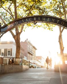 two people walking under an old sacramento sign