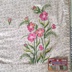 a white blanket with pink flowers on it