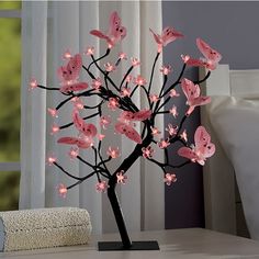 a small tree with pink butterflies on it