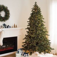 a decorated christmas tree in front of a fireplace