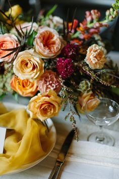 the table is set with flowers and place cards