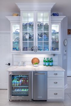 a kitchen with white cabinets and stainless steel refrigerator freezer next to an ice chest