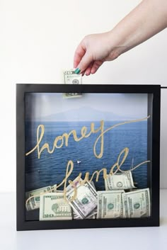 a person holding money in front of a frame