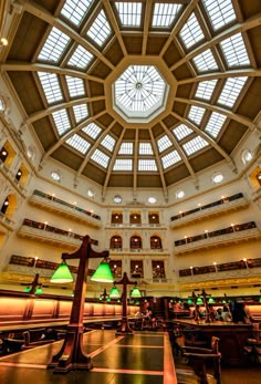 the inside of a large building with many tables and lamps on it's ceiling