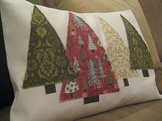 three christmas trees on a pillow sitting on a couch