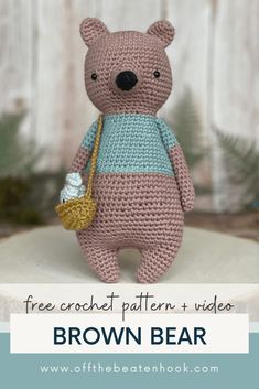 a crocheted teddy bear holding a basket and bottle with the text free crochet pattern video brown bear