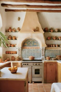 a kitchen with pots and pans on the shelves above the stove, along with an oven