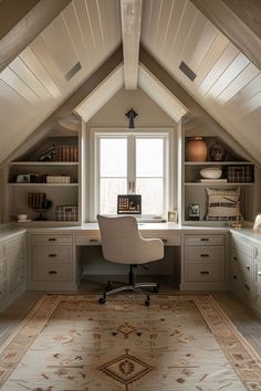 an attic home office with built - in desk and storage cabinets, along with a rug on the floor