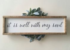 a sign that says it is well with my soul hanging on the wall next to a plant