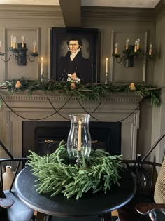 a christmas mantle with candles and greenery on it in front of a fireplace mantel