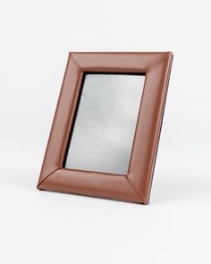 a brown leather photo frame with a mirror