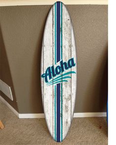 a surfboard with the word aloha on it is leaning against a wall