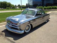 an old car is parked on the side of the road