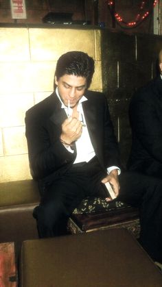 two men in tuxedos sitting next to each other