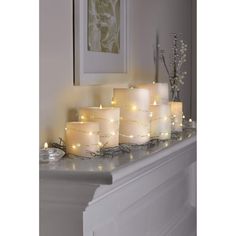 lit candles are sitting on a mantle