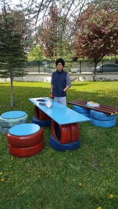 a man standing in front of a blue table with red and blue tires on it