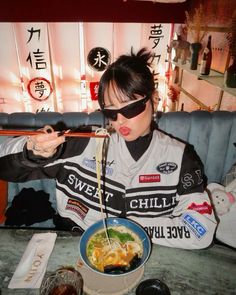 a woman eating noodles from a bowl with chopsticks