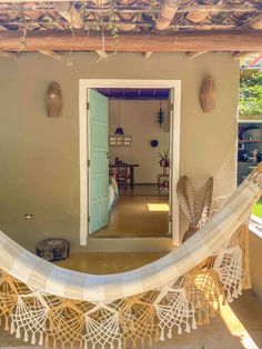 a hammock hanging from the side of a house in front of a door