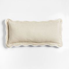 a white pillow with scalloped edges on a white background, it is made from linen