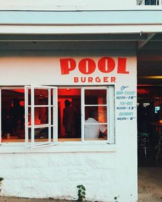 a restaurant called pool burger with people sitting in the window and eating out of it