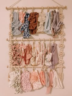 several different types of clothes hanging on a wall with rope and pegs attached to it