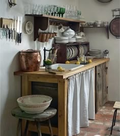 an old fashioned kitchen with lots of dishes on the counter