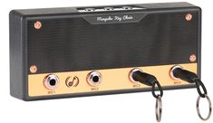 a black and gold amplifier with two keys hanging from it's front end, on a white background