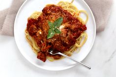 a white plate topped with spaghetti and meat sauce