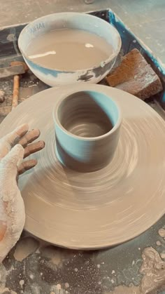 a potter's wheel being used to make a bowl on a pottery wheel with his hands