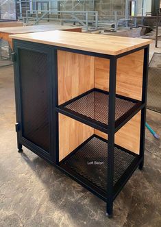 a kitchen island made out of wood and black metal with an open shelf on top